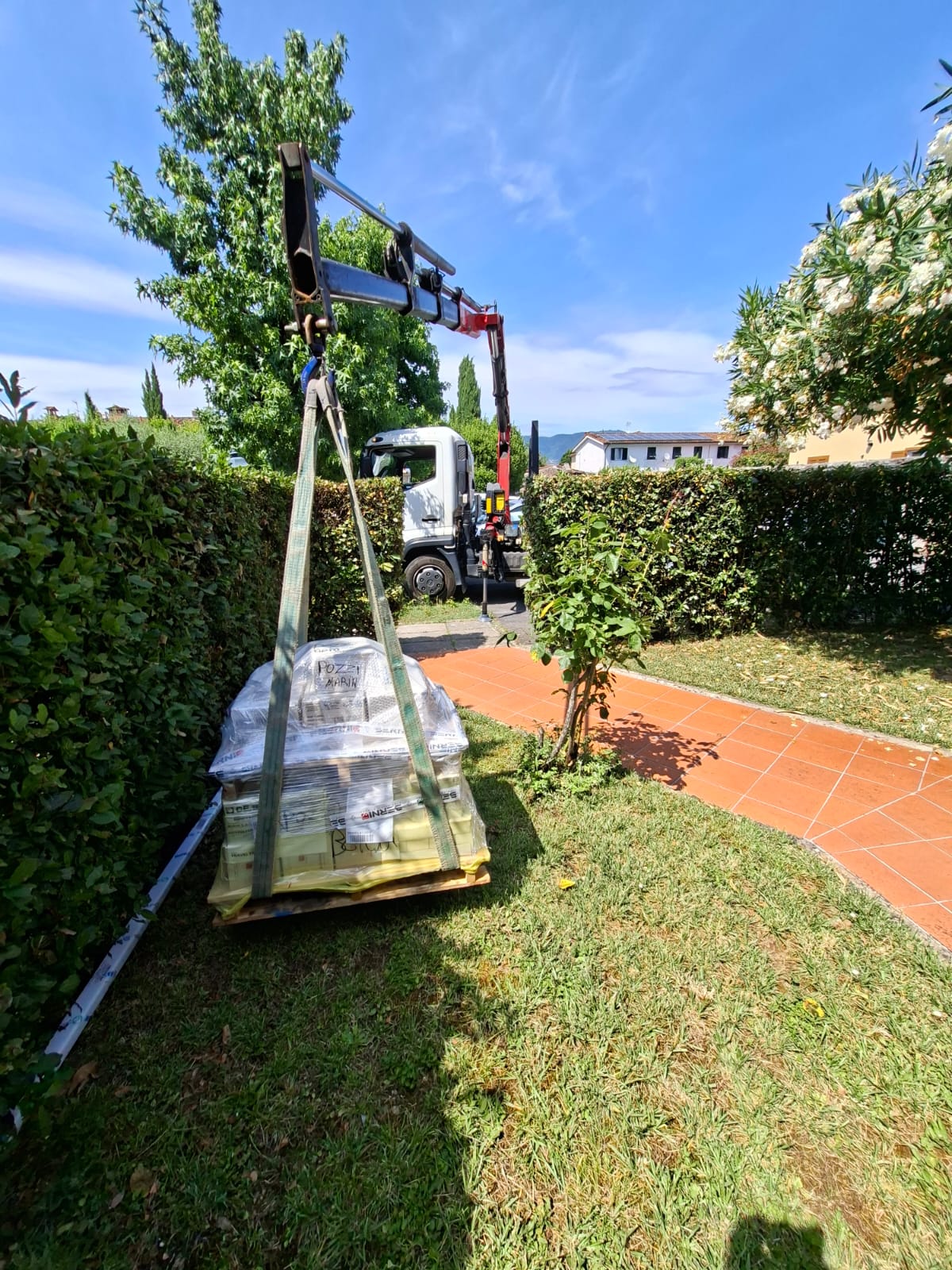 Trasporto materiali edili con camion gru in area residenziale