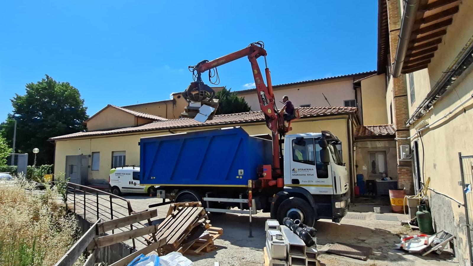 Motrice con gru Strategia Futura durante smaltimento rifiuti